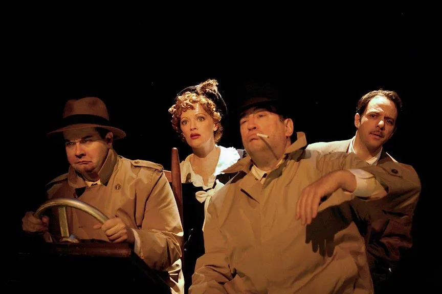 A man dressed as a character from the television show "Petticoat Journey" holds his hands up in front of him with one cigarette in each hand. The other two characters are standing to either side of him smiling for the camera.
2 men and woman posing for picture wearing costumes.