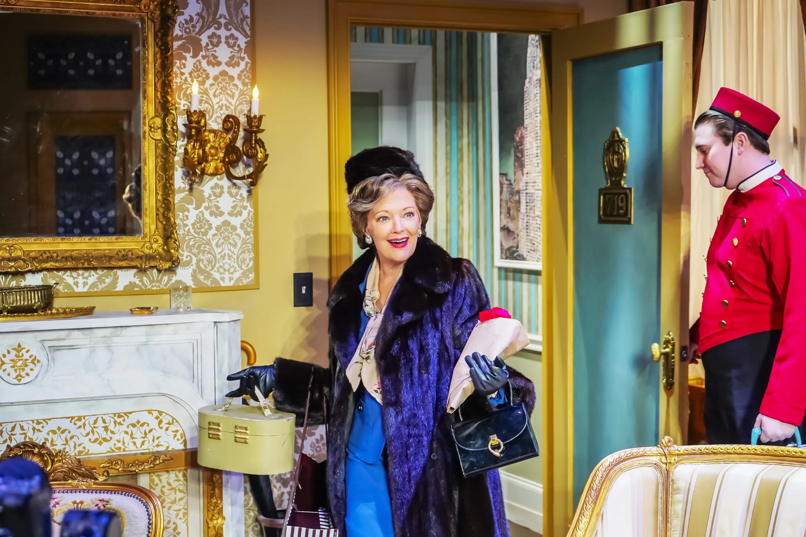 A woman wearing a purple coat walks towards the camera with another person standing next to her watching.